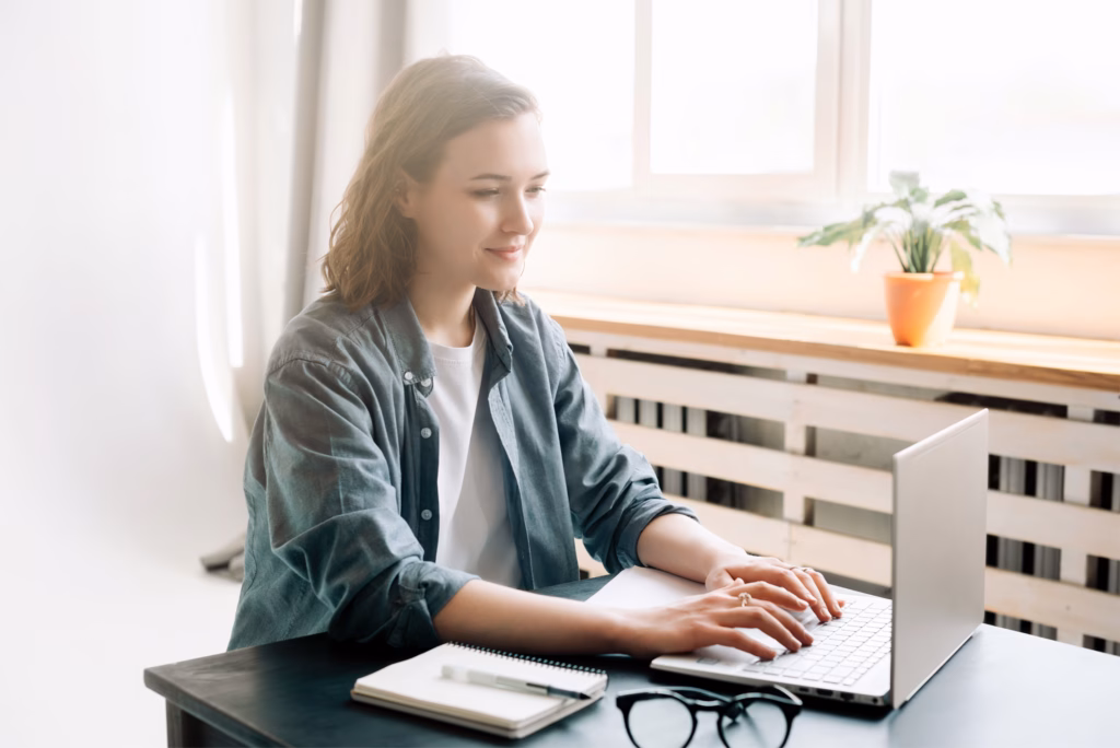 Women sat at a desk next to a window on a laptop reading 'it's a phase' blog