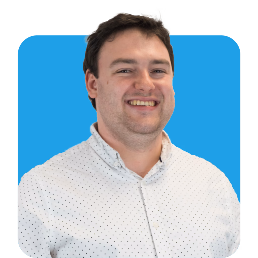a headshot of a man smiling in front of a blue background