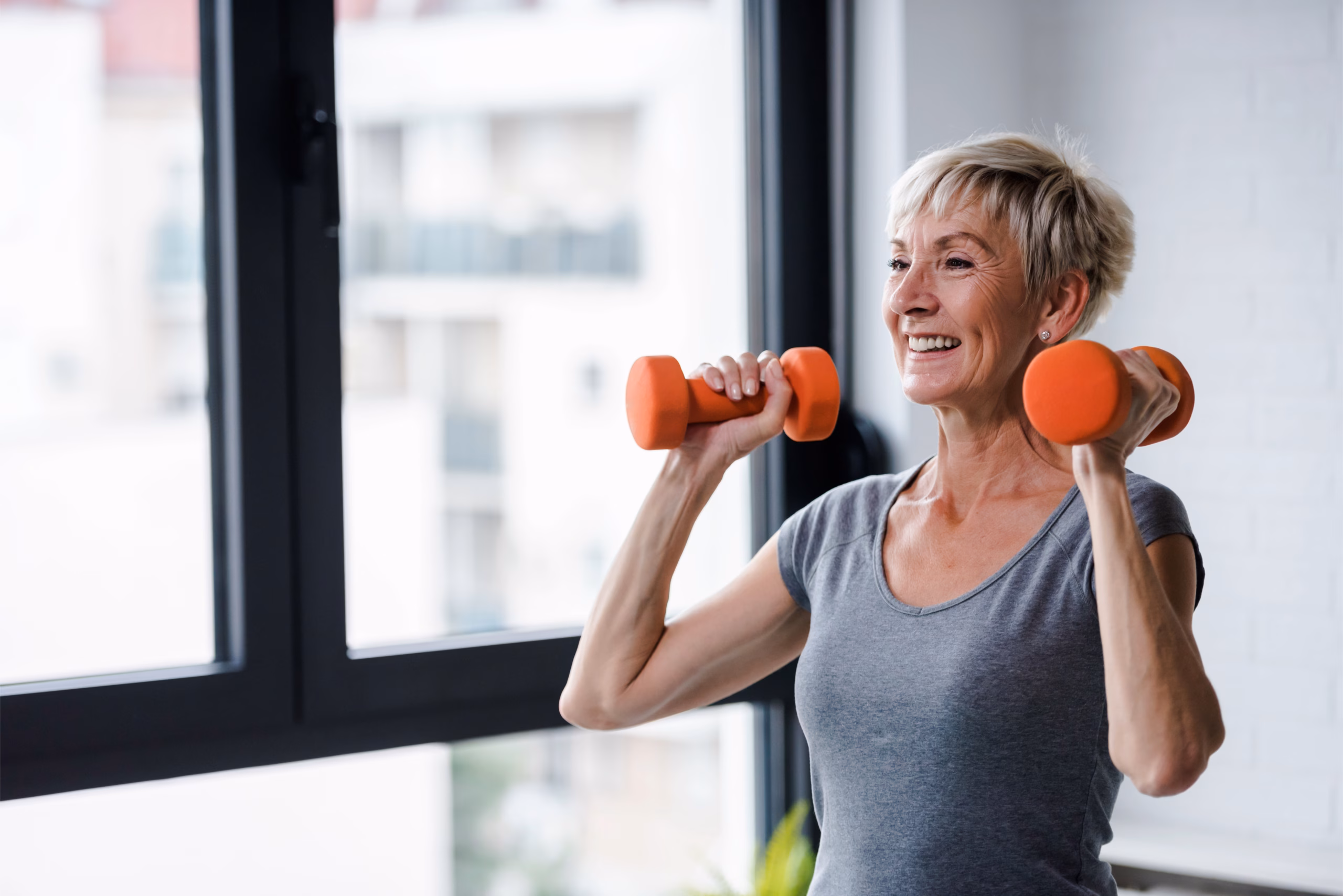 Woman smiling holding two small weights