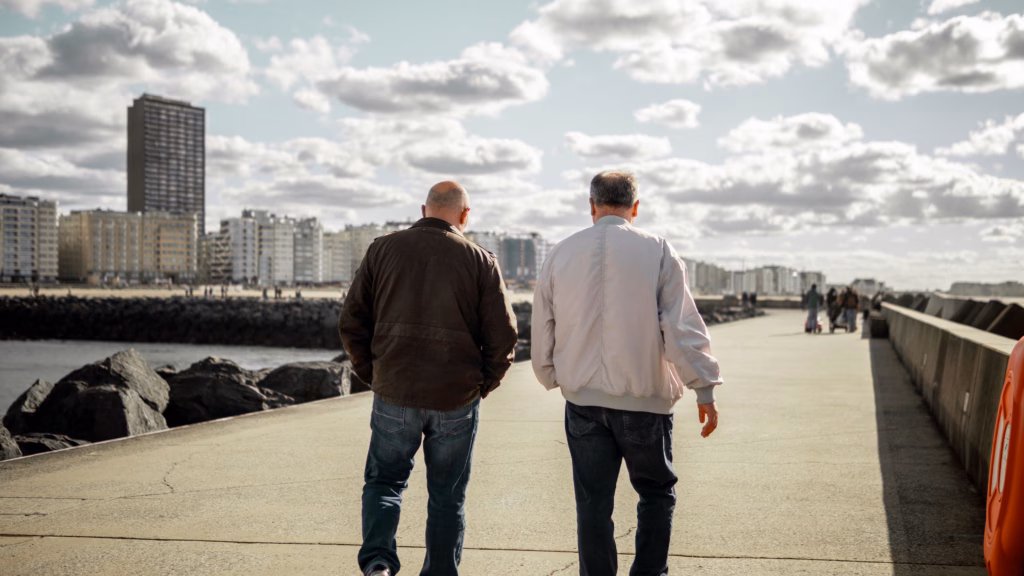 two men walking down a promenade chatting