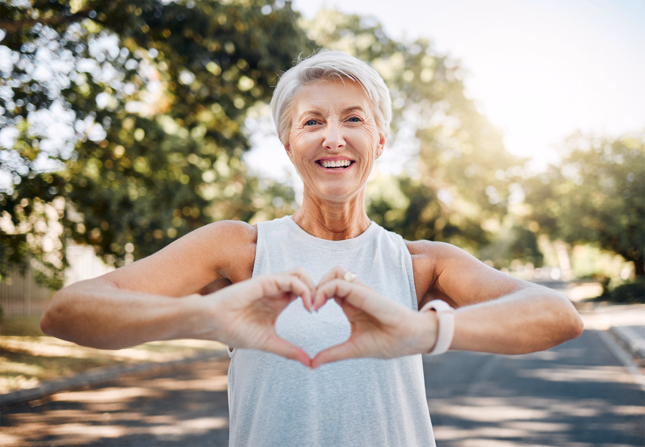 women stood in the street holding up her hands in the shape of a heart